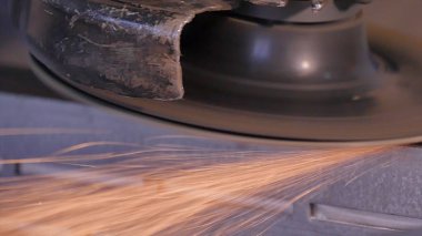 Disk öğütücü atölye ile metal testere ustası. Metal kıvılcım uçan taşlama. Çelik fabrika düşük hızlı çekim yapısında taşlama elektrikli tekerlekli. metal ile turuncu uçan taşlama