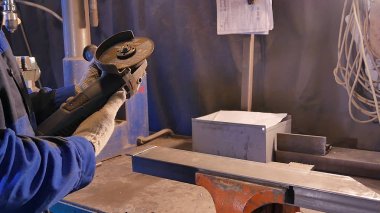 Zanaatkar atölyede disk öğütücüyle metal testeresi kesiyor. Metal testereyle kesiliyor. Metal testeresi üreten bir işçi. Ağır çekimde endüstri