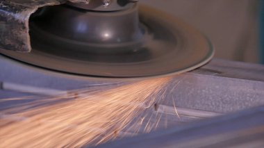 Disk öğütücü atölye ile metal testere ustası. Metal kıvılcım uçan taşlama. Çelik fabrika düşük hızlı çekim yapısında taşlama elektrikli tekerlekli. metal ile turuncu uçan taşlama