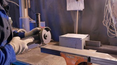 Zanaatkar atölyede disk öğütücüyle metal testeresi kesiyor. Metal testereyle kesiliyor. Metal testeresi üreten bir işçi. Ağır çekimde endüstri