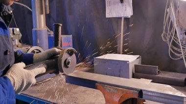 Zanaatkar atölyede disk öğütücüyle metal testeresi kesiyor. Metal testereyle kesiliyor. Metal testeresi üreten bir işçi. Ağır çekimde endüstri