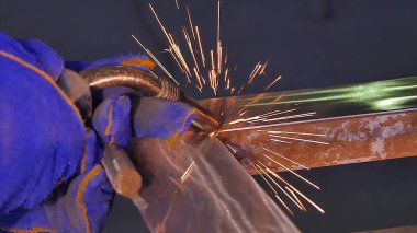 Metal kaynak kıvılcım ve duman ile. İşçi kaynak metal koruyucu maske ile. Kaynakçı metal parçalar katılır. Bir yarı otomatik kaynak kullanan işlem. Kaynak çelik. Fabrikada sanayi işçisi