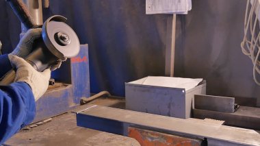 Zanaatkar atölyede disk öğütücüyle metal testeresi kesiyor. Metal testereyle kesiliyor. Metal testeresi üreten bir işçi. Ağır çekimde endüstri