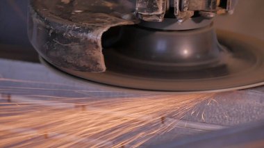 Disk öğütücü atölye ile metal testere ustası. Metal kıvılcım uçan taşlama. Çelik fabrika düşük hızlı çekim yapısında taşlama elektrikli tekerlekli. metal ile turuncu uçan taşlama