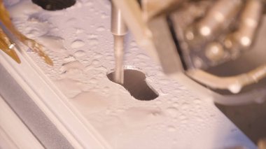 Alüminyum ve metal delinmiştir delik. Alüminyum veya metal metal atölyesinde closeup sondaj. Yassı çelik plaka Delme tezgah matkap ile çalışan. Alüminyum ve metal kesme delik