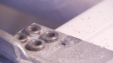 Alüminyum ve metal elektrikli matkap kullanarak delinmiştir delik. Alüminyum veya metal metal atölyesinde closeup elektrikli matkapla Delme. Yassı çelik plaka Delme tezgah matkap ile çalışan.