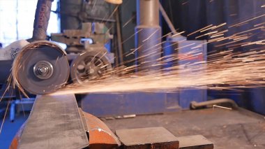 Zanaatkar atölyede disk öğütücüyle metal testeresi kesiyor. Metal testereyle kesiliyor. Metal testeresi üreten bir işçi. Ağır çekimde endüstri