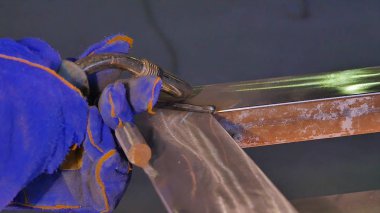 Metal kaynak kıvılcım ve duman ile. İşçi kaynak metal koruyucu maske ile. Kaynakçı metal parçalar katılır. Bir yarı otomatik kaynak kullanan işlem. Kaynak çelik. Fabrikada sanayi işçisi