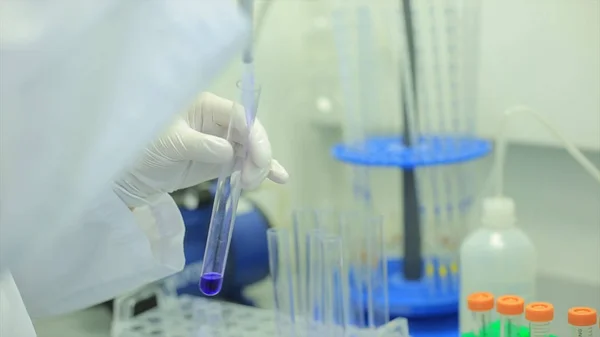 Primer plano de los tubos de ensayo. Equipo médico. Imágenes de cerca de un científico usando una micro pipeta en un laboratorio. Técnico de laboratorio inyectando líquido en una placa de microtitulación. Tubos de ensayo. Pequeña profundidad de — Foto de Stock