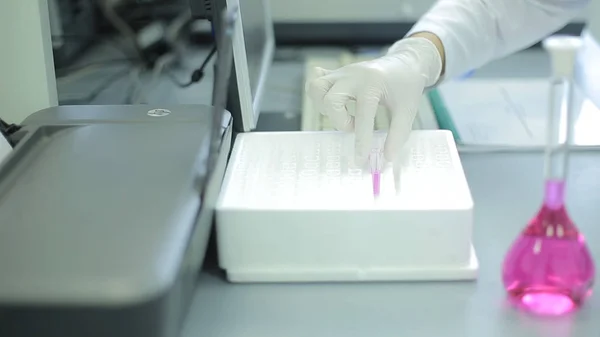 젊은 여성 실험실 기술자 원뿔 유리 삼각 플라스 크를 검사 화학 검사를 실시 하는 동안 녹색 액체 솔루션으로 가득 합니다. 실험실 작업자 플라스 크 시 약으로 검사합니다. 영, 남성 — 스톡 사진