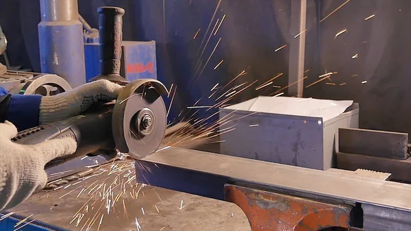 Craftsman sawing metal with disk grinder in workshop. Metal sawing close up. Worker in production sawing metal. Industry in slow motion — Stock Photo, Image