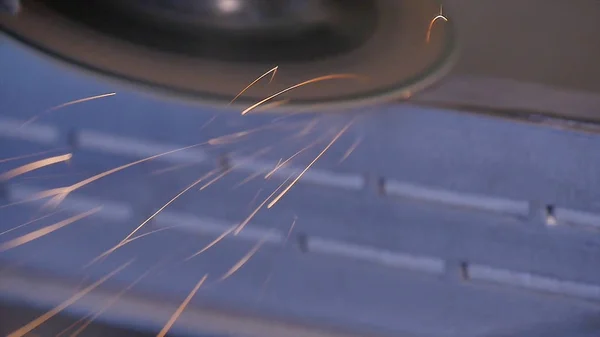 Iparos fűrészelés fém lemez grinder műhelyben. Őrlés fém szikra repül. Elektromos kerék köszörülés acélszerkezet-gyár alacsony zársebesség. fém köszörülés narancssárga repülő — Stock Fotó