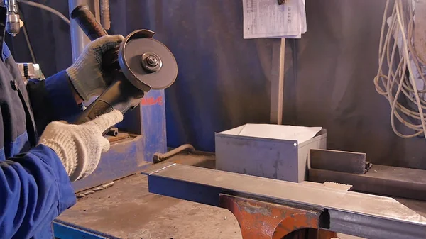 Zanaatkar atölyede disk öğütücüyle metal testeresi kesiyor. Metal testereyle kesiliyor. Metal testeresi üreten bir işçi. Ağır çekimde endüstri