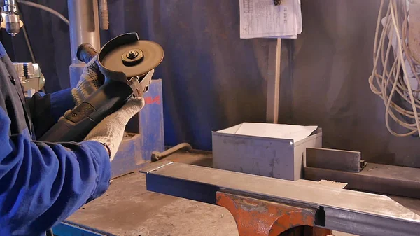 Zanaatkar atölyede disk öğütücüyle metal testeresi kesiyor. Metal testereyle kesiliyor. Metal testeresi üreten bir işçi. Ağır çekimde endüstri