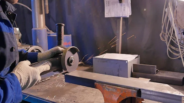 Zanaatkar atölyede disk öğütücüyle metal testeresi kesiyor. Metal testereyle kesiliyor. Metal testeresi üreten bir işçi. Ağır çekimde endüstri