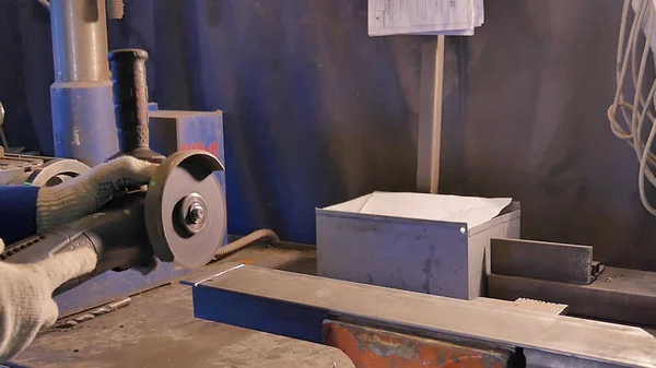 Artesano aserrado de metal con amoladora de disco en taller. Aserrado de metal de cerca. Trabajador en la producción de aserrado de metal. Industria en cámara lenta —  Fotos de Stock