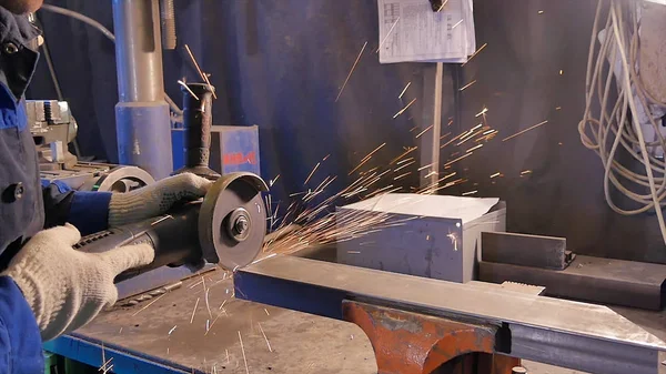 Craftsman sawing metal with disk grinder in workshop. Metal sawing close up. Worker in production sawing metal. Industry in slow motion — Stock Photo, Image