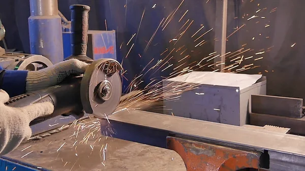 Craftsman sawing metal with disk grinder in workshop. Metal sawing close up. Worker in production sawing metal. Industry in slow motion — Stock Photo, Image