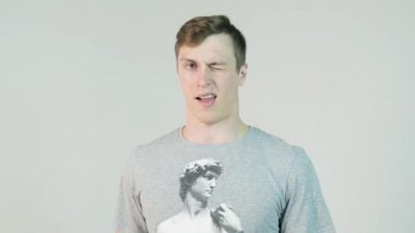 Mutlu bir adam bir göz kırpıyor yakın çekim. genç adam göz kırpıyor. kışkırtıcı kırpışan adam