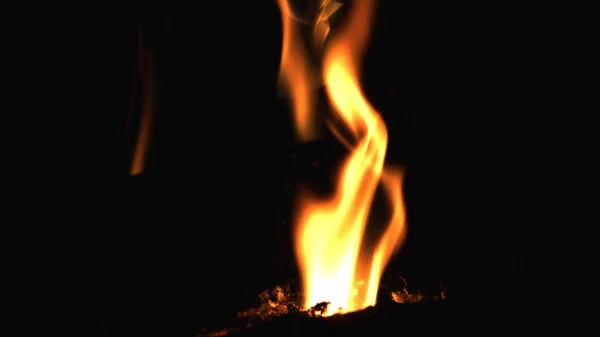 Nahaufnahme von brennendem rotem Feuerholz auf schwarzem Hintergrund. Brennholz im Kamin verbrennen. — Stockfoto