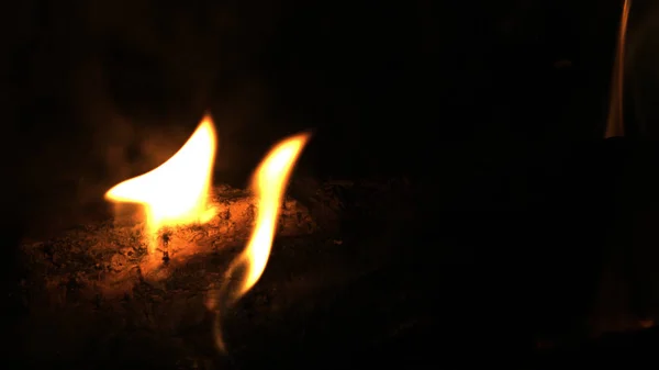 Nahaufnahme von brennendem rotem Feuerholz auf schwarzem Hintergrund. Brennholz im Kamin verbrennen. — Stockfoto