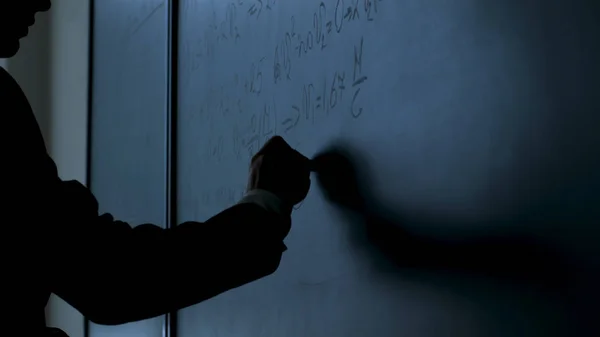 Cientista a escrever fórmulas no quadro. Mão com giz escreveu fórmulas de física em closeup quadro preto — Fotografia de Stock
