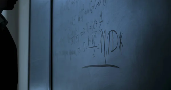 Επιστήμονας στέκεται κοντά τους τύπους πίνακα κιμωλίας. Φόρμουλες φυσικής στον μαύρο πίνακα κιμωλίας — Φωτογραφία Αρχείου