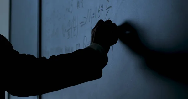 Ученый пишет формулы на доске. Рука с мелом написала формулы физики на черной доске крупным планом — стоковое фото