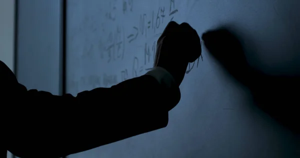 Forskare skriva formler på svarta tavlan. Hand med krita skrev fysik formler på svarta tavlan närbild — Stockfoto