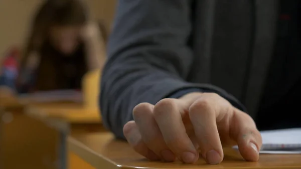 Schüler tippen mit den Fingern in Nahaufnahme. Junger Mann tippt mit den Fingern auf einen Tisch — Stockfoto