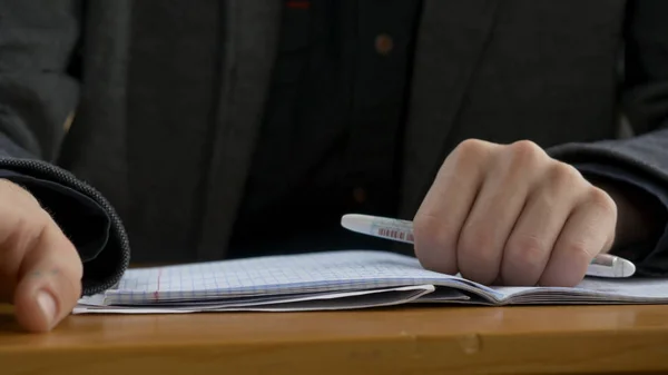 学生手手指攻丝特写。年轻男子轻拍他的手指在桌子上 — 图库照片