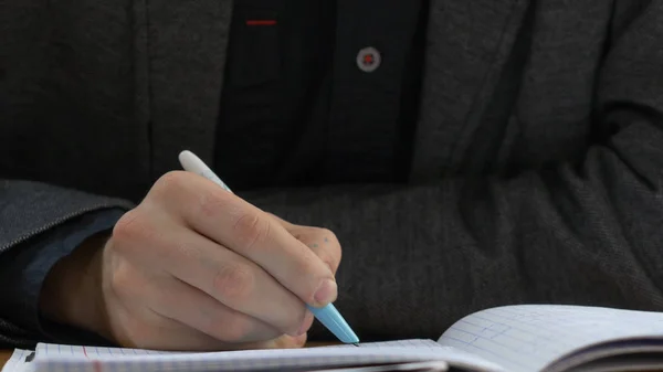 Estudiante escribe en el libro de ejercicios. Estudiante escribe una conferencia — Foto de Stock