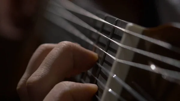 Nahaufnahme von Gitarrist Hand spielt Akustikgitarre. Nahaufnahme eines Mannes, der mit seinen Fingern auf den Bünden einer Gitarre spielt — Stockfoto