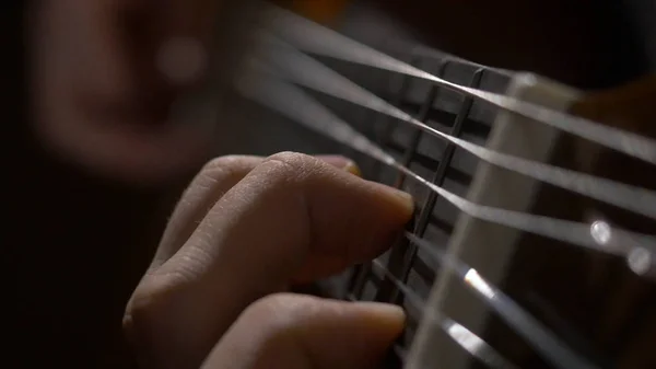 Nahaufnahme von Gitarrist Hand spielt Akustikgitarre. Nahaufnahme eines Mannes, der mit seinen Fingern auf den Bünden einer Gitarre spielt — Stockfoto