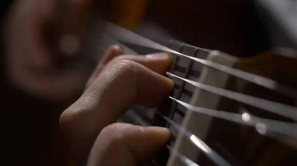 Nahaufnahme von Gitarrist Hand spielt Akustikgitarre. Nahaufnahme eines Mannes, der mit seinen Fingern auf den Bünden einer Gitarre spielt — Stockfoto