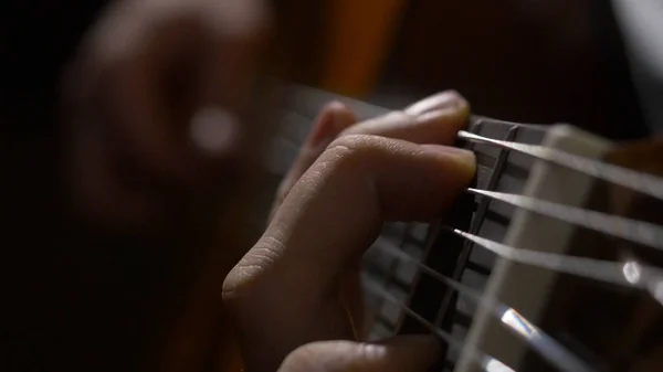 Nahaufnahme von Gitarrist Hand spielt Akustikgitarre. Nahaufnahme eines Mannes, der mit seinen Fingern auf den Bünden einer Gitarre spielt — Stockfoto