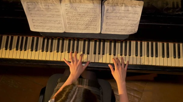 Female piano player, view from the top. Woman plays the piano top view