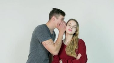 Genç adam bir sır sürpriz genç bir kadın için fısıldayarak. Genç adam bir sır kıza söyler.