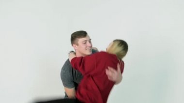 Kız kendini sevgilisi beyaz arka plan üzerinde silah atma. Genç kız erkek kol üzerinde atlar