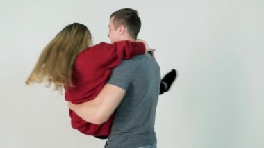 Adam kız ellerinde vardır. Genç adam kızı beyaz arka plan, ağır çekim ellerde açar