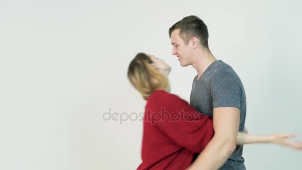 Young man hugging girlfriend. Young couple embraces after a long separation, on a white background — Stock Video