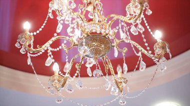 Lüks kristal avize kırmızı tavanda. Ortam ışığı güzel kristal avize