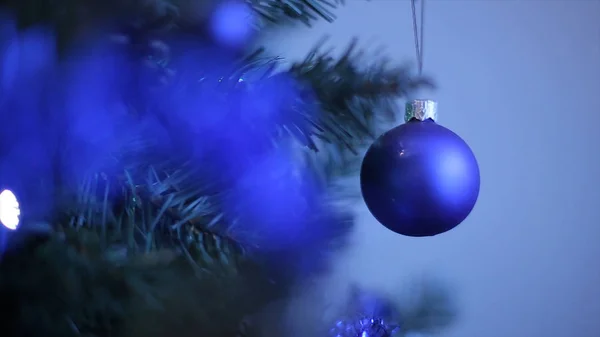雪の結晶や赤いボールのようなクリスマスツリーの新年のおもちゃ。雪の枝の新年の装飾ボール。白い雪の結晶と青のクリスマスボール。選択的焦点 — ストック写真