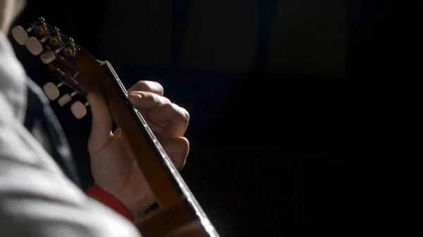 Nahaufnahme von Gitarrist Hand spielt Akustikgitarre. Nahaufnahme eines Mannes, der mit seinen Fingern auf den Bünden einer Gitarre spielt — Stockfoto