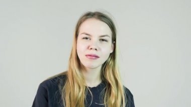 Genç sevimli gülümseyen kadın beyaz zemin üzerine sakız çiğniyor