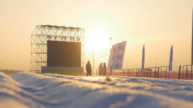 Günbatımı sahne yanında ayakta beyaz karla kaplı yol üzerinde
