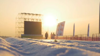 Günbatımı sahne yanında ayakta beyaz karla kaplı yol üzerinde