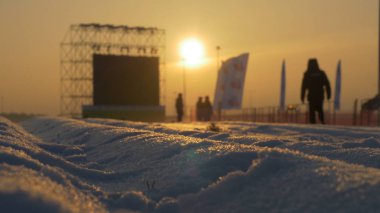 Günbatımı sahne yanında ayakta beyaz karla kaplı yol üzerinde