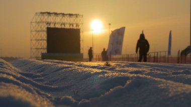 Günbatımı sahne yanında ayakta beyaz karla kaplı yol üzerinde
