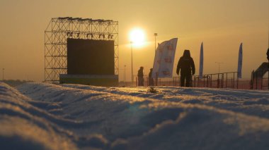 Günbatımı sahne yanında ayakta beyaz karla kaplı yol üzerinde